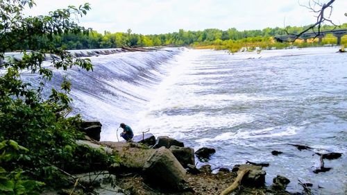 Scenic view of waterfall against sky