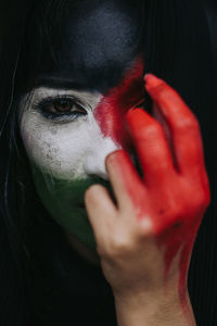 Close-up portrait of woman with red hand