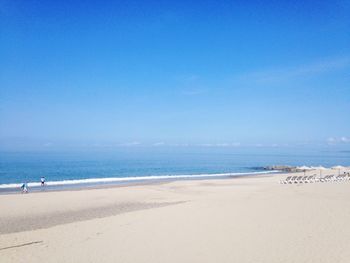 Scenic view of beach against clear blue sky