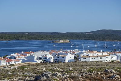 Scenic view of sea by town against clear blue sky