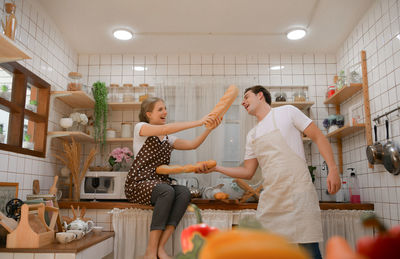 Young couple prepares cooking a breakfast in kitchen with a fun smile and happiness