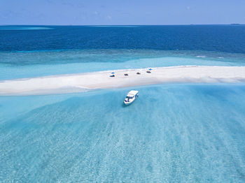 Maldives, aerial view of boat near small sandy islet off coast of indian ocean in summer