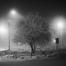 Illuminated street light against sky at night