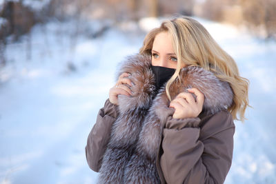 Portrait of woman with dog on snow