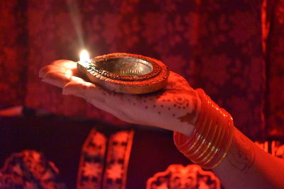 Close-up of hand holding illuminated diya