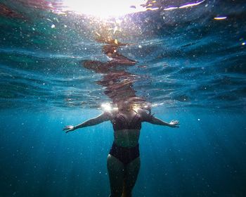 Rear view of woman swimming in sea