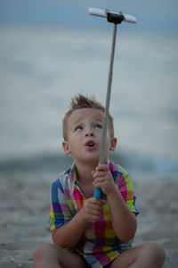 Full length of boy sitting in sea