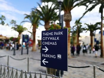 Close-up of information sign against sky