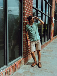 Full length of young man looking through window