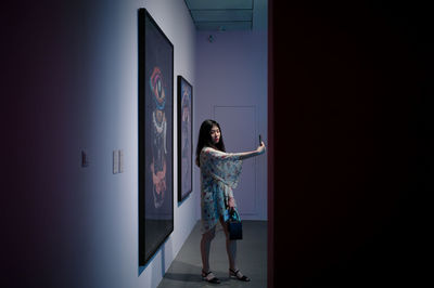 Woman standing against wall at home