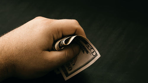 Cropped hand of person holding pocket watch