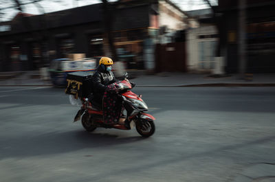 Man riding motorcycle on street in city