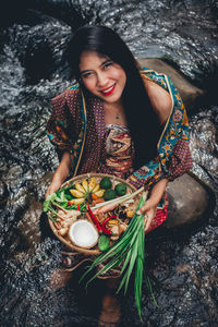 High angle view of young woman holding rock