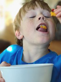 Close-up of boy eating food at home