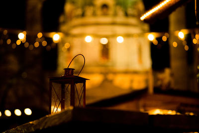 Close-up of illuminated lamp on table at night