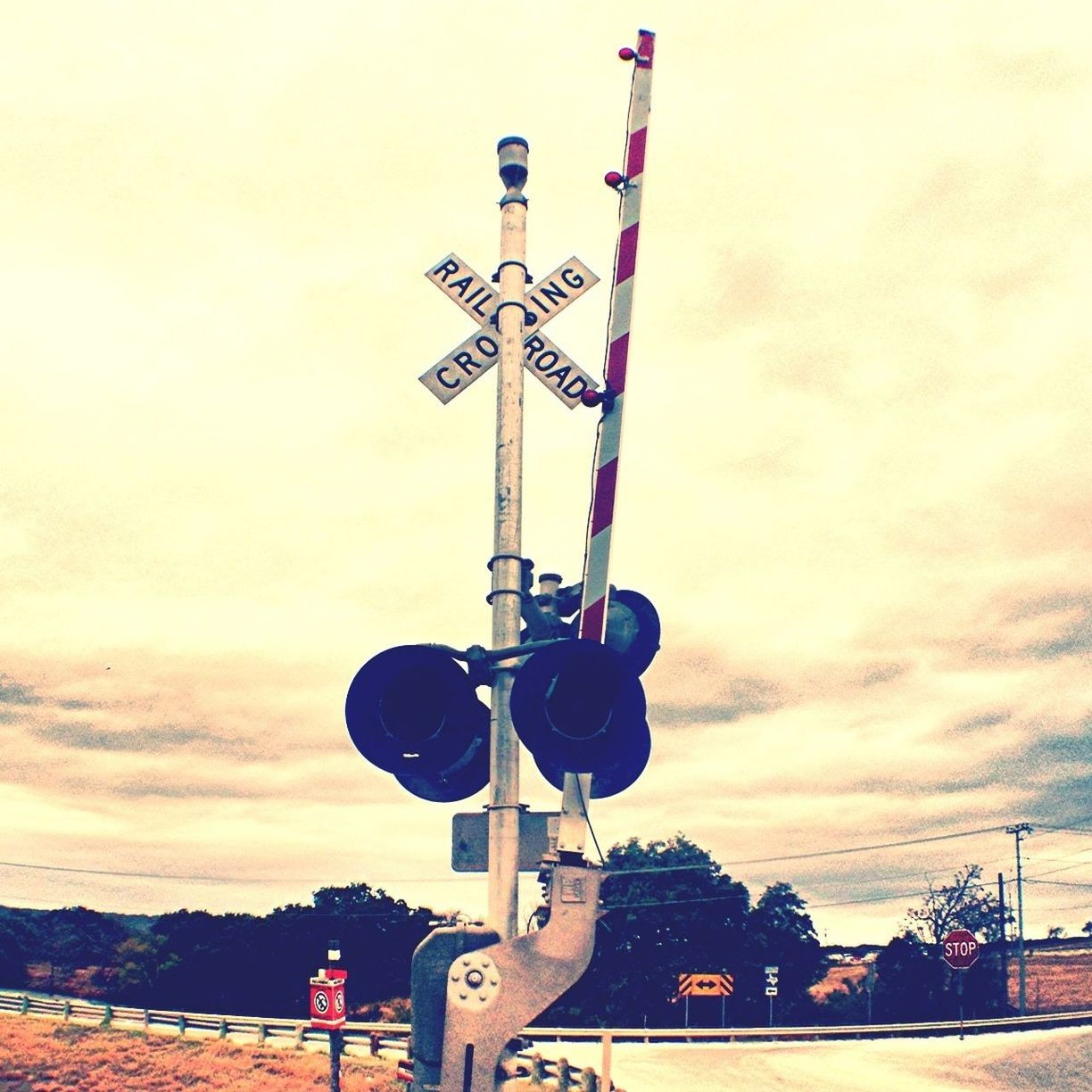 transportation, sky, mode of transport, cloud - sky, land vehicle, car, communication, road sign, street light, built structure, low angle view, sunset, outdoors, guidance, crane - construction machinery, architecture, industry, no people, day, road