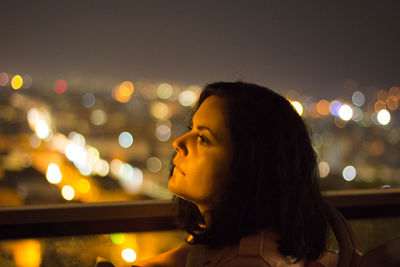 Portrait of young woman looking away at night