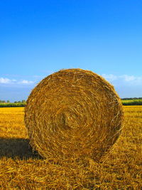 Hay bales on field against sky