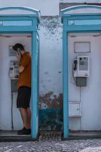 Woman standing by telephone booth