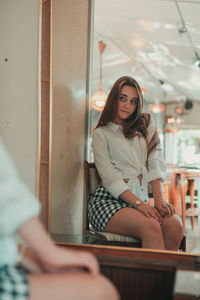 Beautiful young woman reflecting in mirror