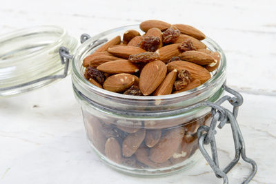 High angle view of almonds and raisins in jar on table