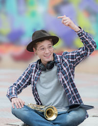 Portrait of smiling young man holding hat