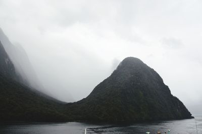 Scenic view of sea and mountains against sky