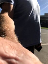 Close-up of shirtless man hand on street