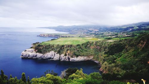 Scenic view of sea and mountains against sky