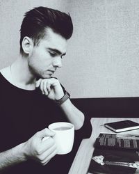 Close-up of man drinking coffee cup on table