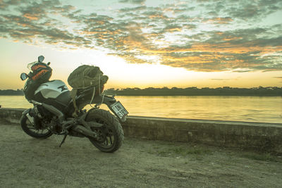 Horse cart on land against sky during sunset