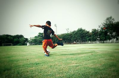 Full length of girl running on grassy field