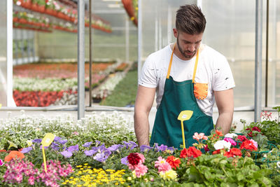 Full length of man working on flowering plants