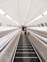 Low angle view of woman standing on escalator