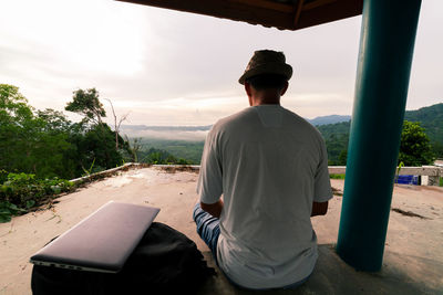 Rear view of man sitting in gazebo