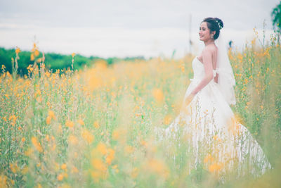 Full length of woman standing on field against sky