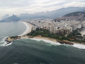 Aerial view of sea and buildings against sky