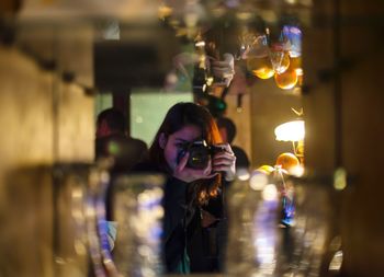 Woman photographing bottles through camera