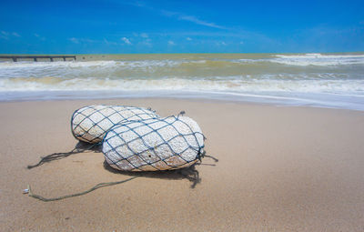 Deck chairs on beach against sky