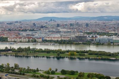 River amidst buildings in city against sky