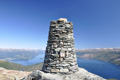 Stack of rocks against blue sky