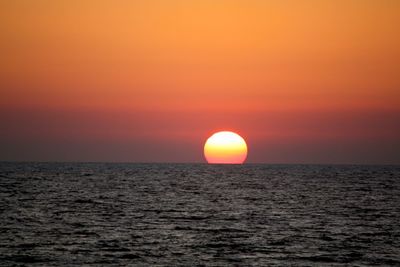 Scenic view of sea against orange sky