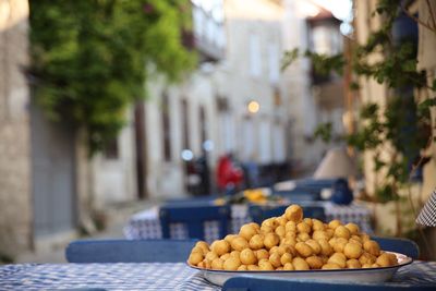 Heap of potatoes on table at sidewalk cafe in city