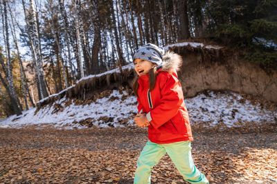 Full length of boy standing in forest