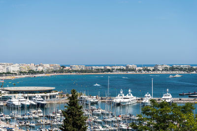 High angle view of boats moored on sea against clear blue sky during sunny day