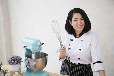 Portrait of smiling chef standing in kitchen