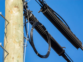 Low angle view of crane against clear blue sky