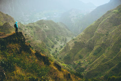 Male hiker on top of the mountain rock with gorgeous panorama view over valley