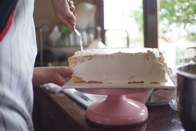 Midsection of person preparing cake