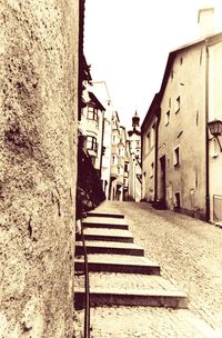 Narrow alley amidst buildings against clear sky